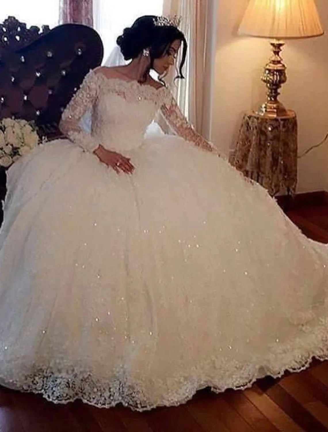 Elegant off-shoulder long sleeve lace ball gown wedding dress with intricate beading and sequins.