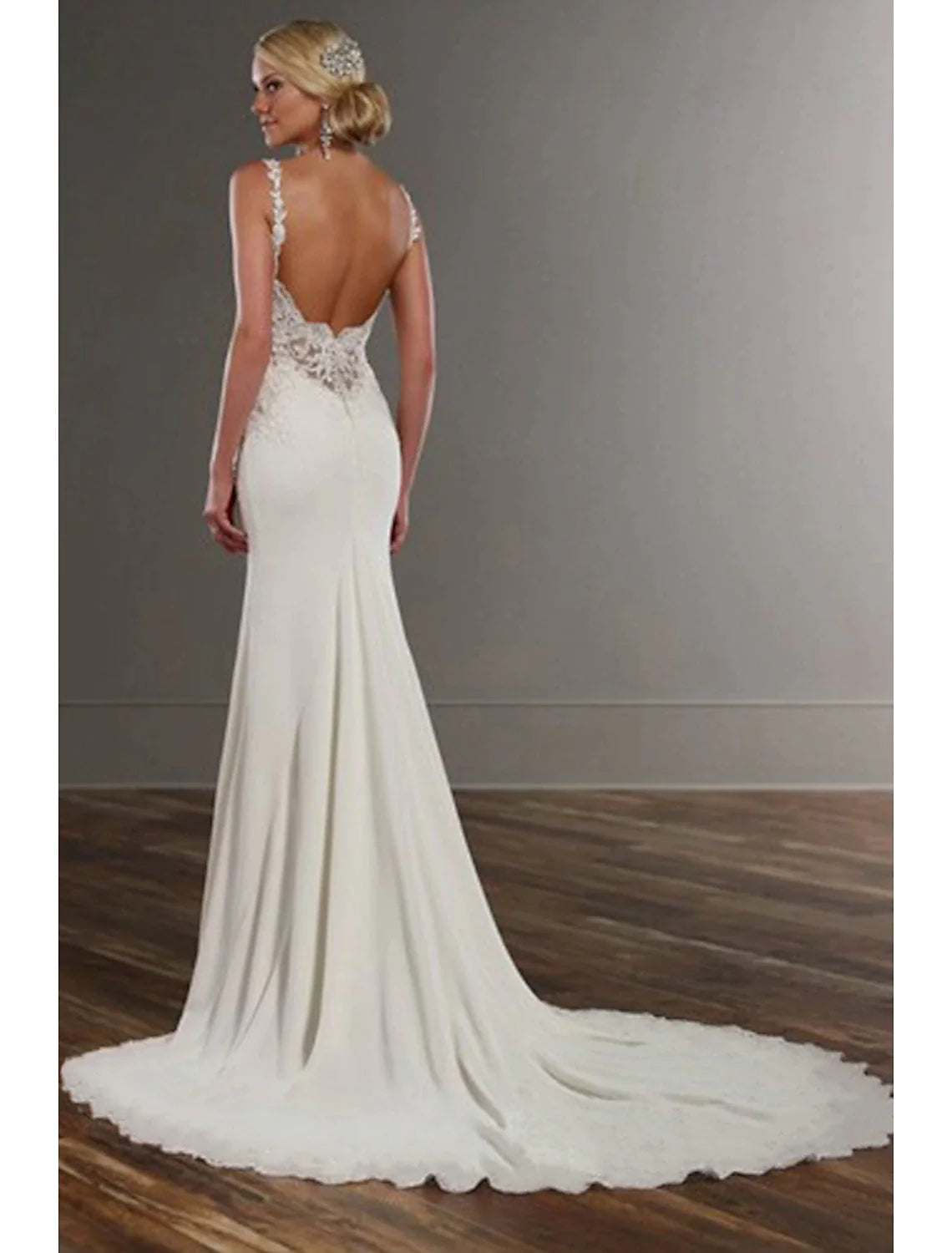 Side view of a mermaid wedding dress with a flowing train.