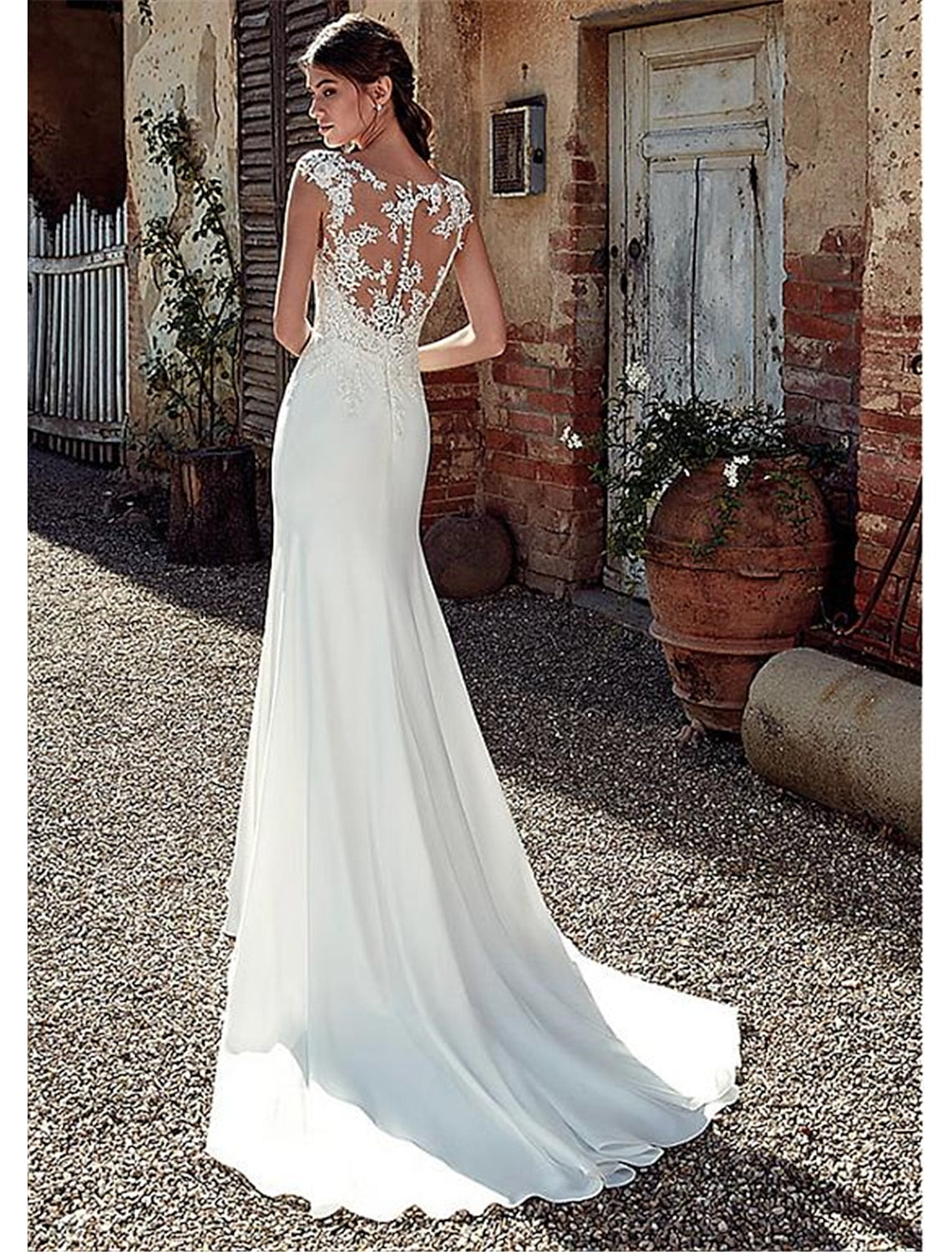 Back view of the white mermaid wedding dress, showing the open back and court train.