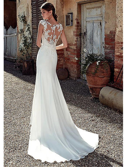 Back view of the white mermaid wedding dress, showing the open back and court train.