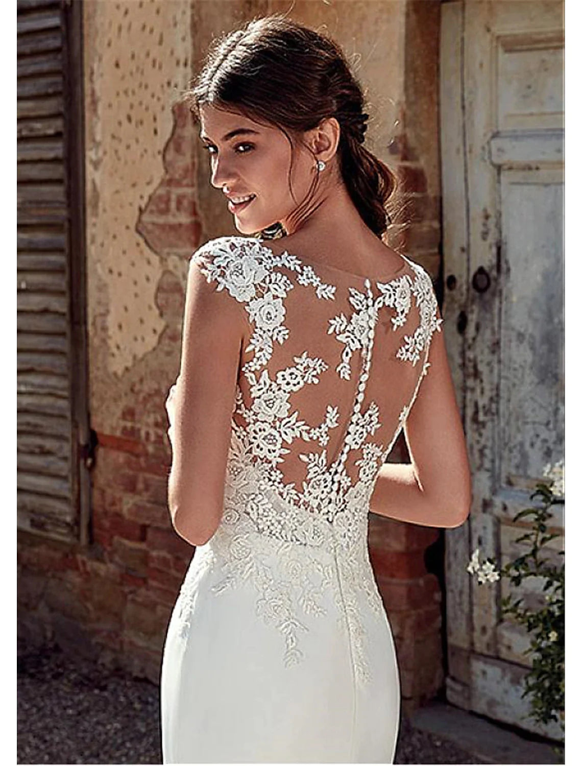 Close-up of the illusion neckline and applique details on the white wedding dress.