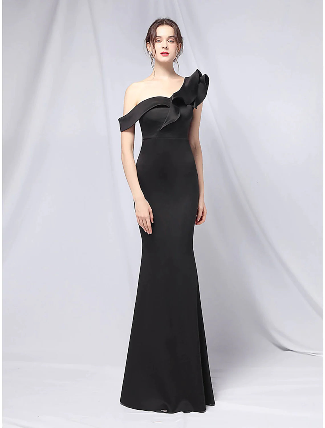 Side view of a stretch satin mermaid gown, highlighting the ruffled skirt.
