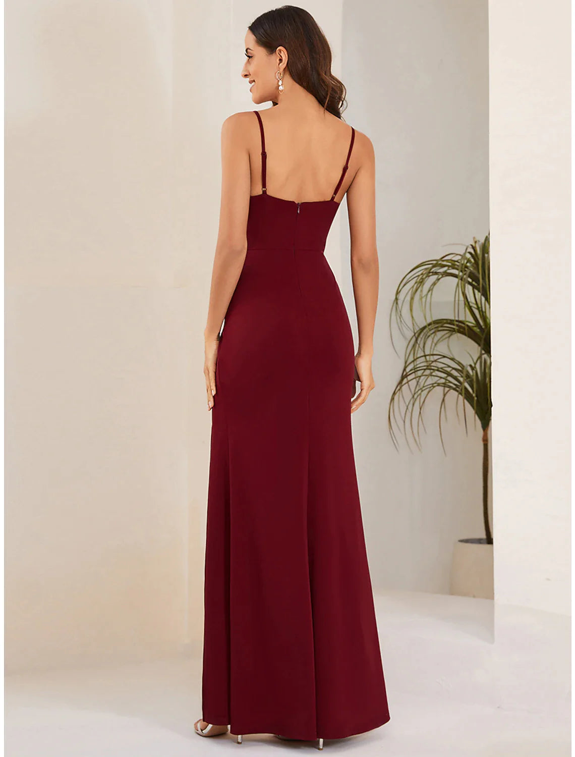 Woman gracefully walking in a long formal wedding guest dress.