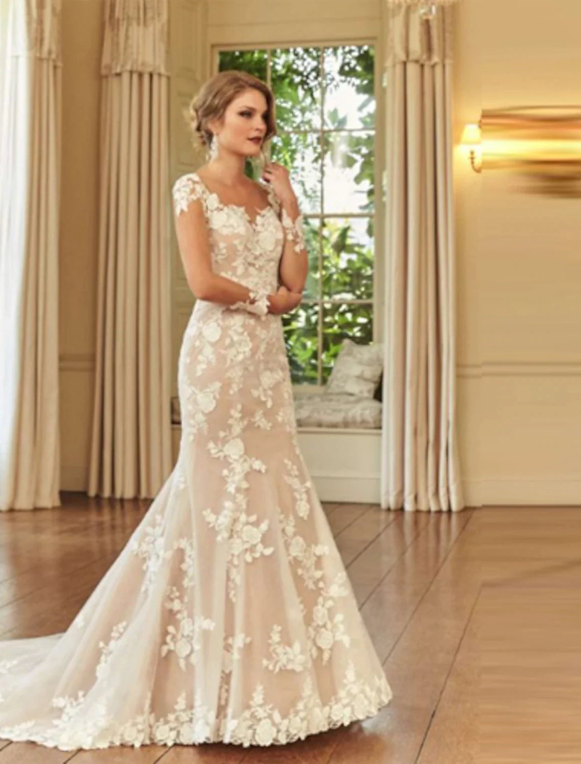 Elegant mermaid trumpet wedding dress with illusion neck, long sleeves, and lace embroidery.