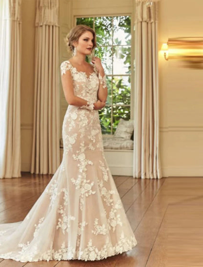 Elegant mermaid trumpet wedding dress with illusion neck, long sleeves, and lace embroidery.