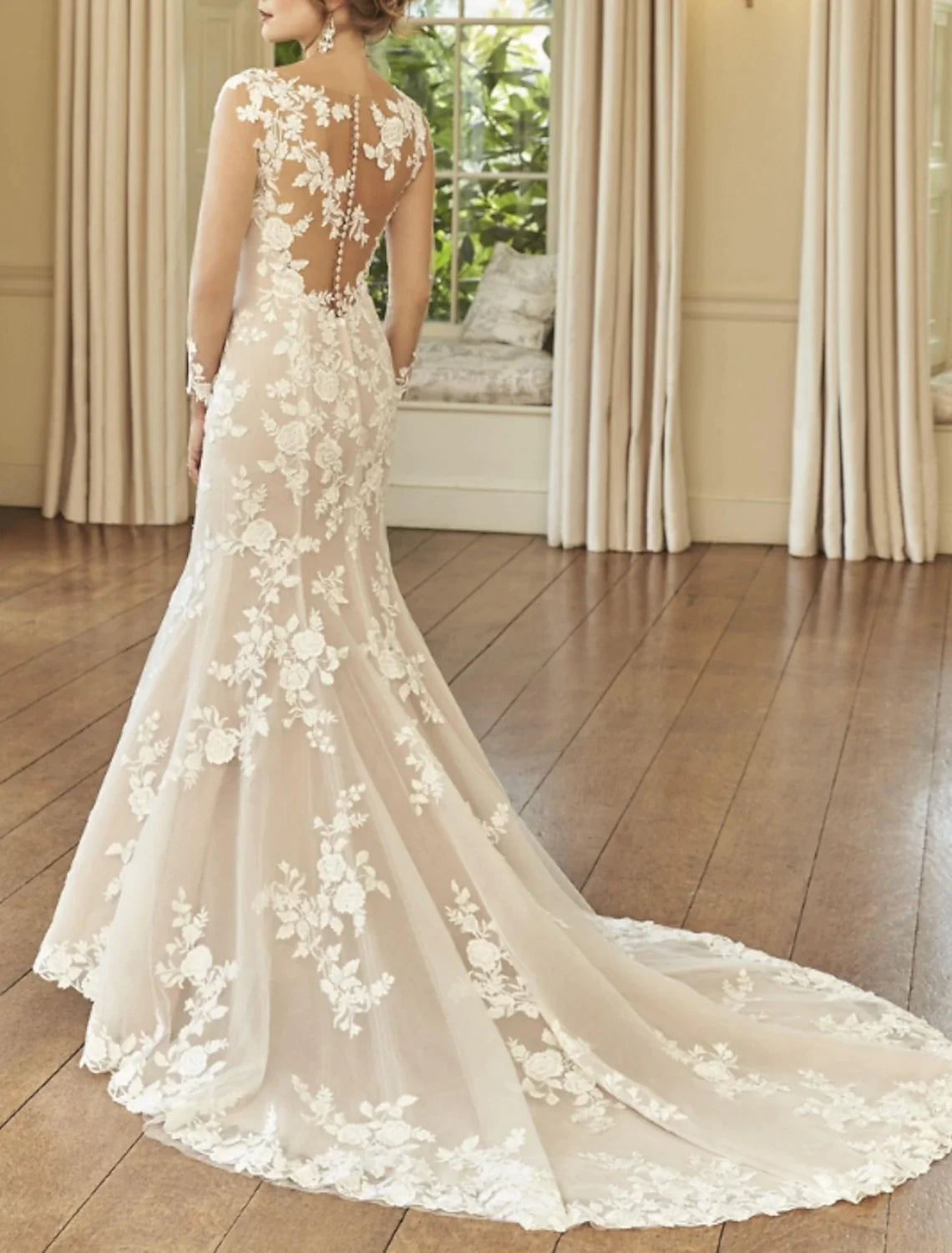Close-up of the back of the lace wedding dress, showing court train and intricate embroidery.
