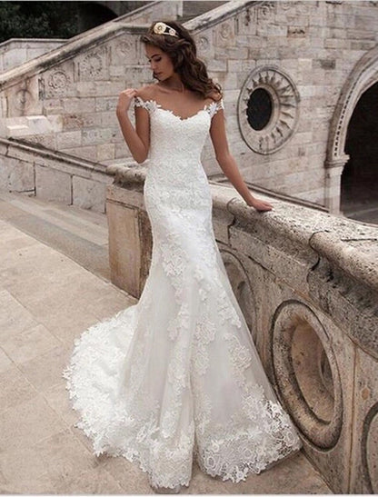 Close-up of the off-shoulder neckline and intricate lace appliques on the bridal gown.