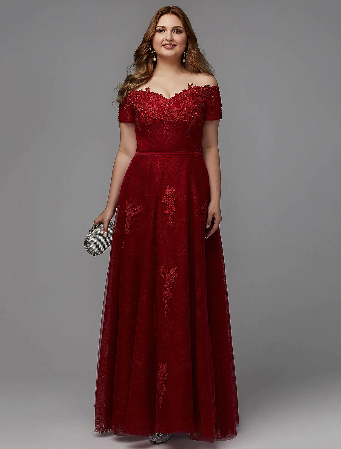 Plus size A-line wedding guest dress with off-shoulder neckline and lace details.