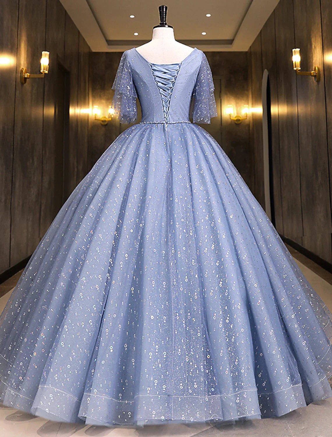 Back view of the floor-length Quinceanera ball gown, showcasing the full skirt.