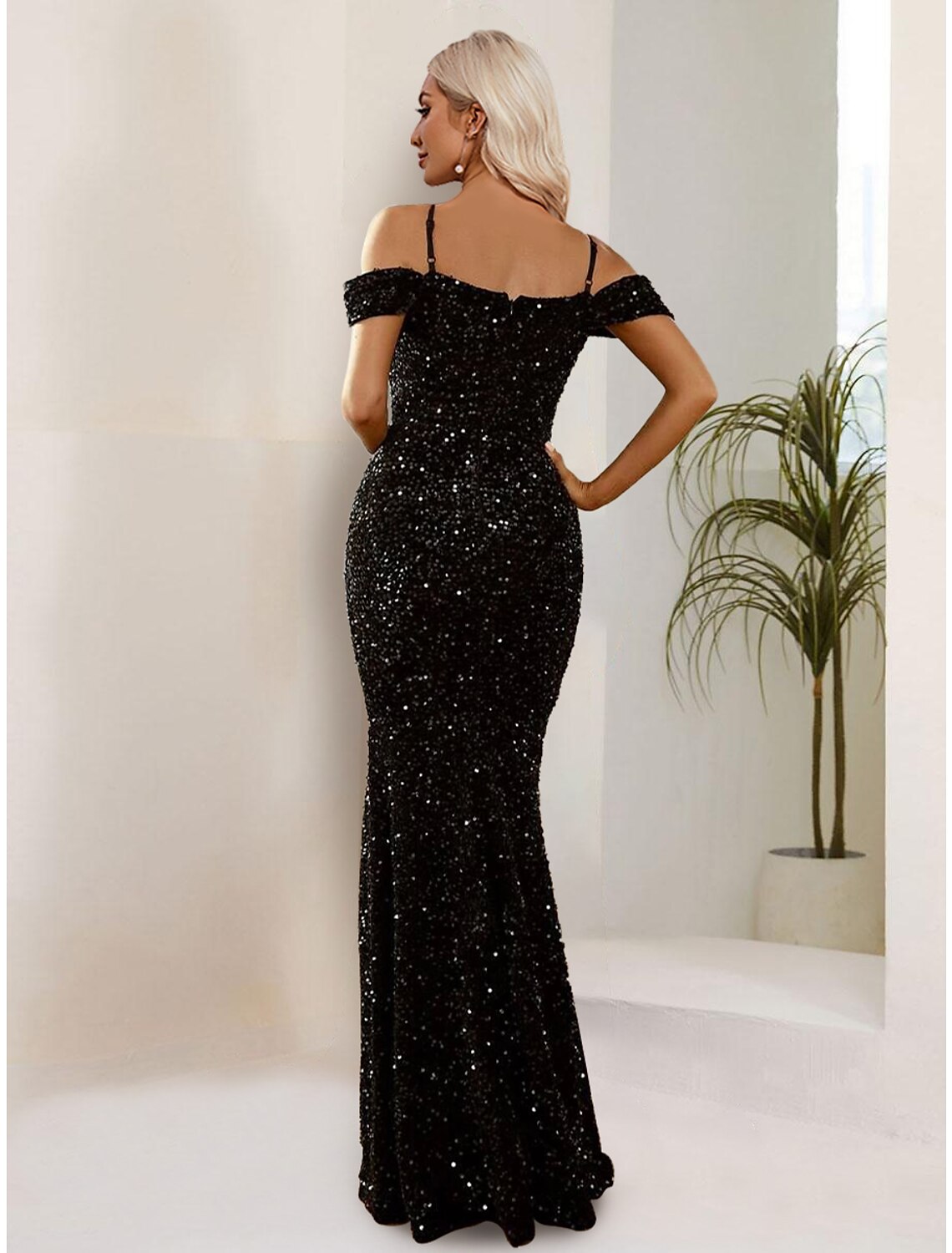 Side profile of a woman in a shimmering black sequined mermaid formal dress.