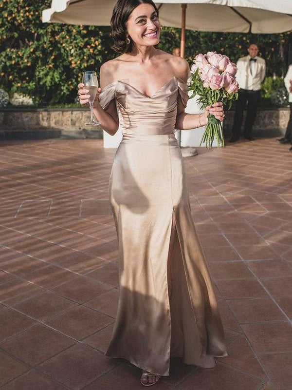 A woman wearing an elegant, ruched off-the-shoulder, floor-length bridesmaid dress made of silk-like satin.