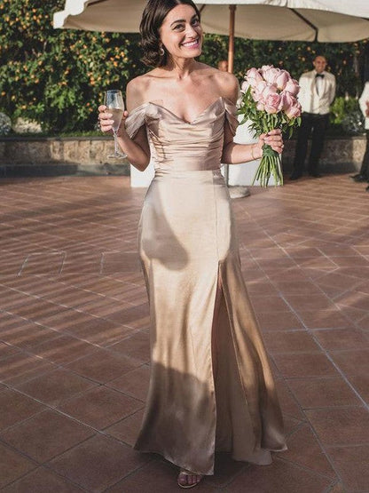 A woman wearing an elegant, ruched off-the-shoulder, floor-length bridesmaid dress made of silk-like satin.