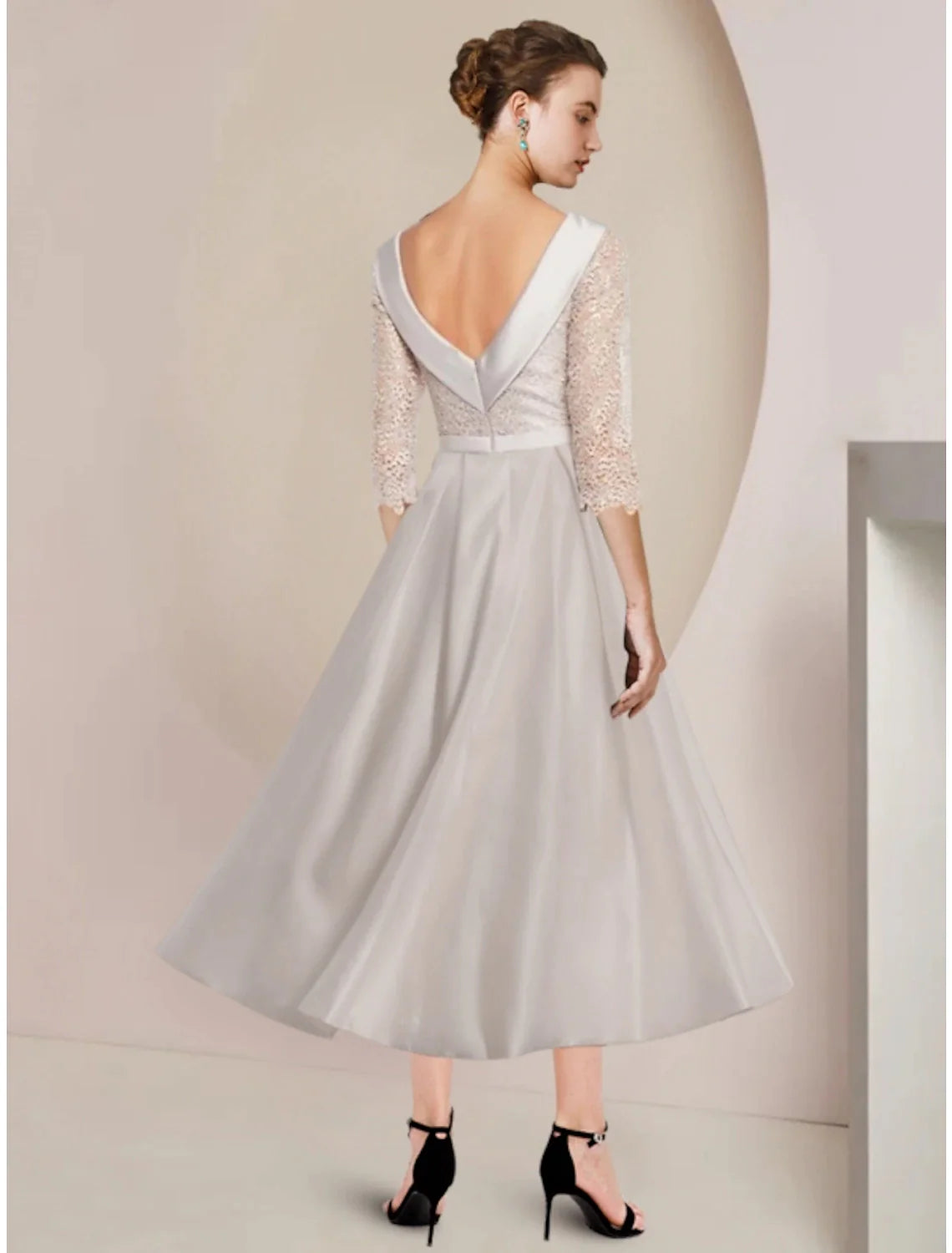 Close-up of the scoop neckline and half sleeve on the elegant satin dress.