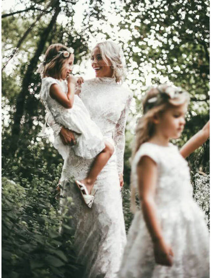 Boho sheath wedding dress with high neck and long sleeves.
