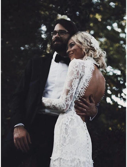 Side view of a bride in a long sleeve lace wedding gown with court train.
