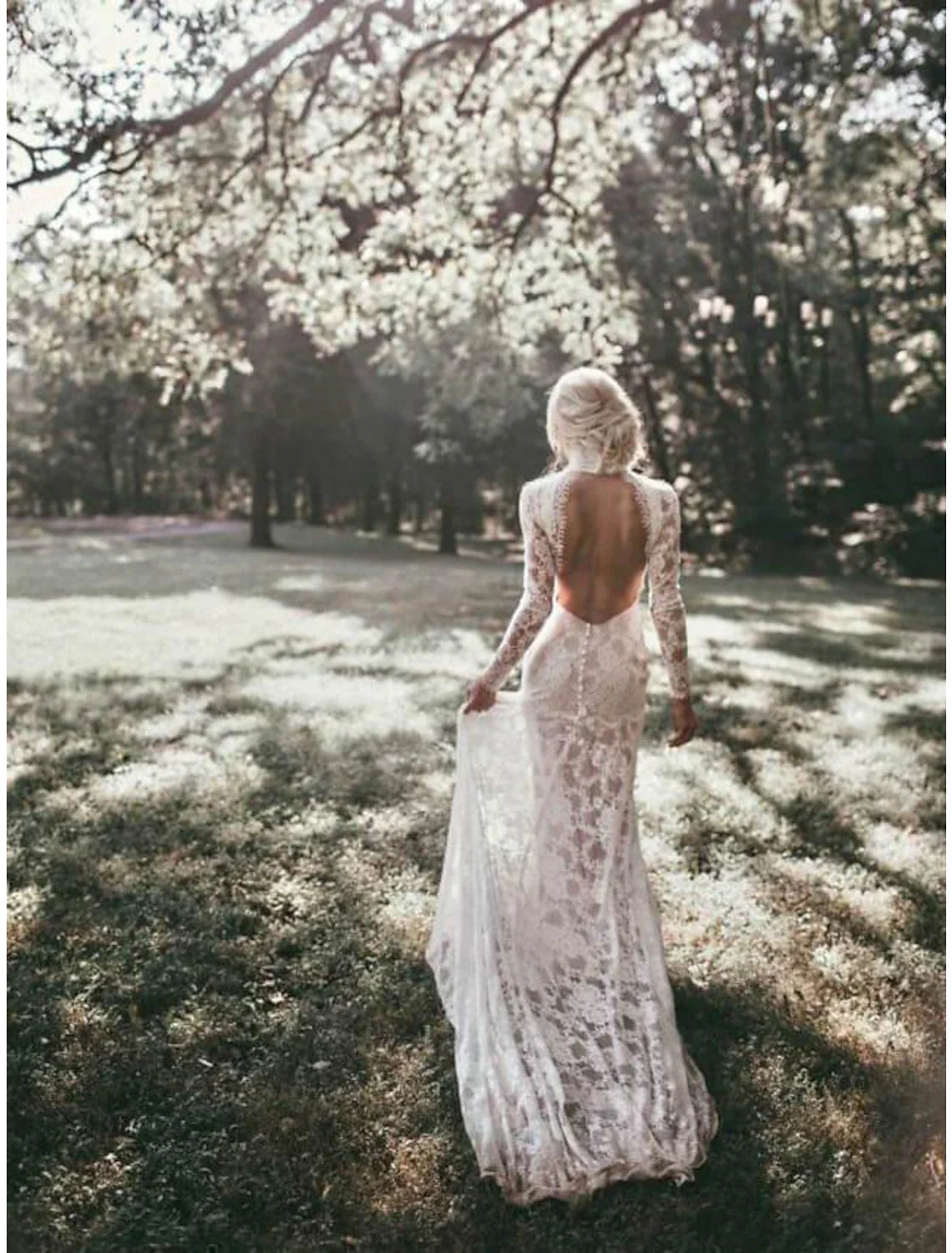 Bride posing in a flowing sheath wedding dress with bohemian details.