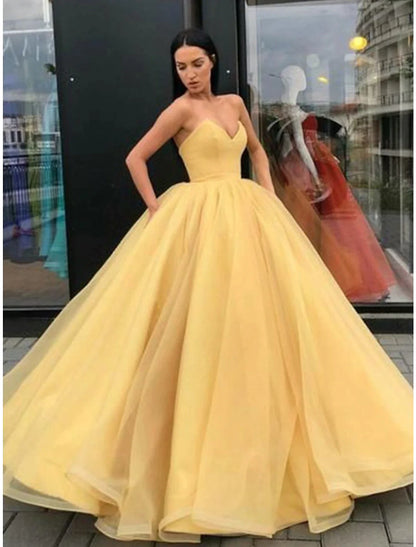 Elegant strapless ball gown with a beautiful back, floor-length tulle skirt, and sleek pleats.