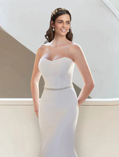 Side profile of a bride wearing the elegant two-piece strapless wedding dress.