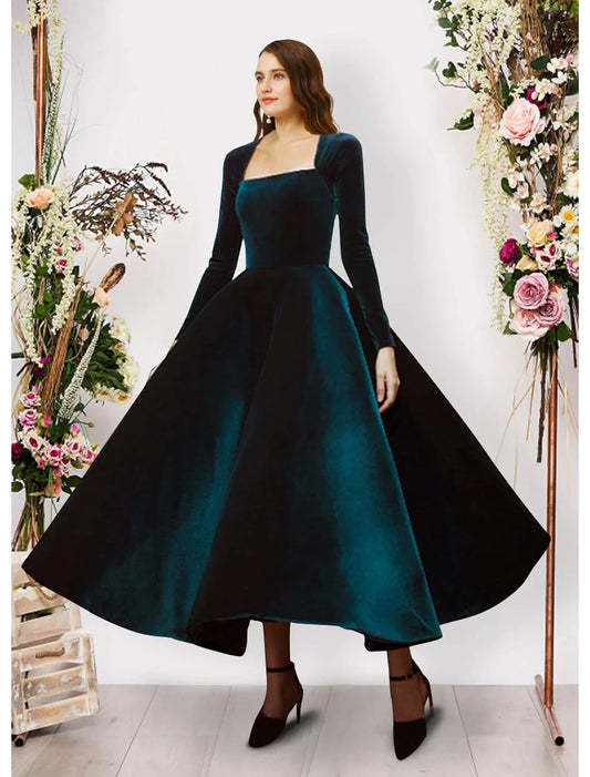 Woman wearing a dark velvet long-sleeve square-neck ball gown, front view.