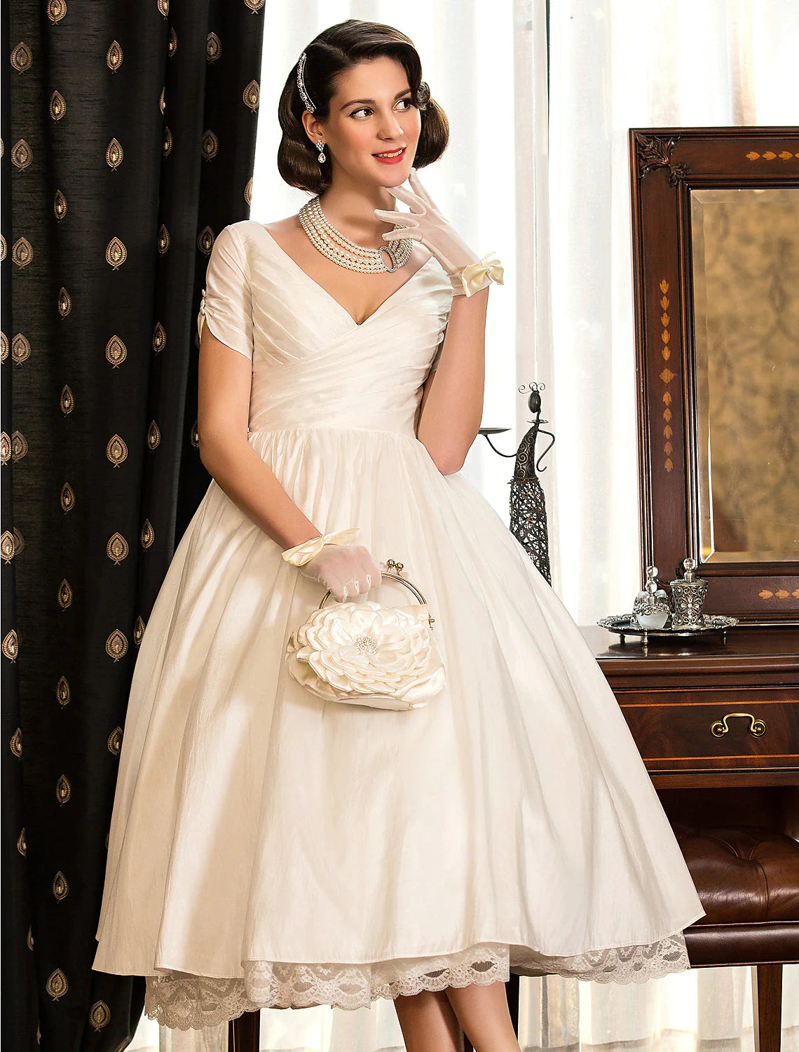 Side view of the tea-length satin bridal gown featuring lace criss-cross details.