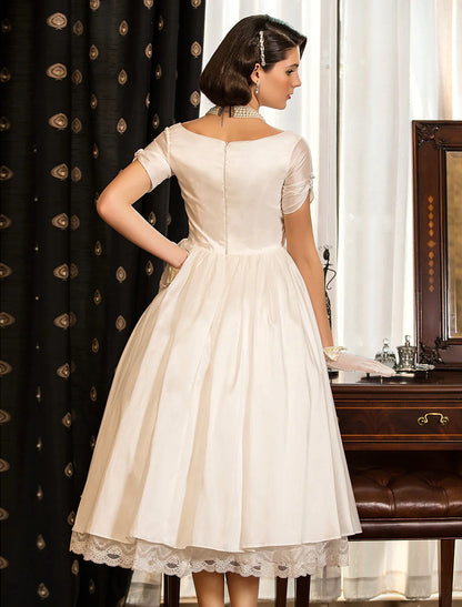 Close-up of the V-neckline and short sleeves on the vintage white wedding dress.