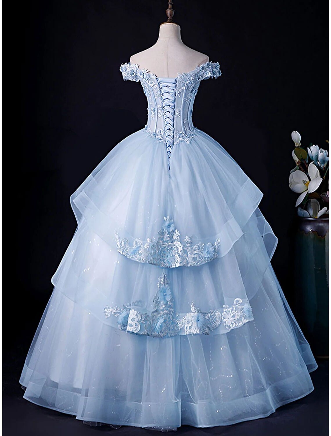 White off-shoulder ball gown with full skirt, side view.