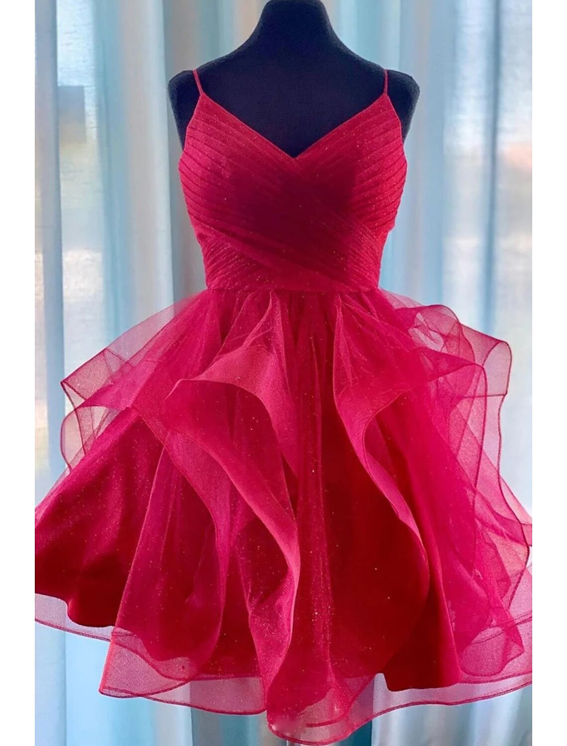 Model wearing a glitter tulle A-line ball gown with spaghetti straps.