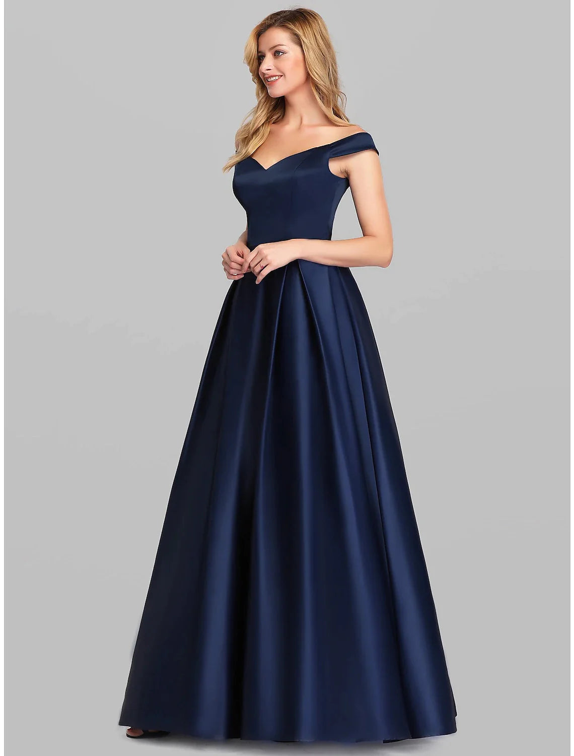 Woman wearing a sophisticated A-Line charmeuse evening gown with a plunging neckline and ruched bodice.