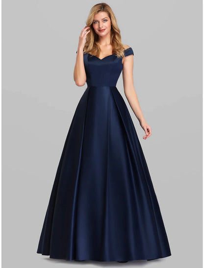 Side view of a woman in a dark A-Line charmeuse gown, highlighting the elegant ruched detailing.