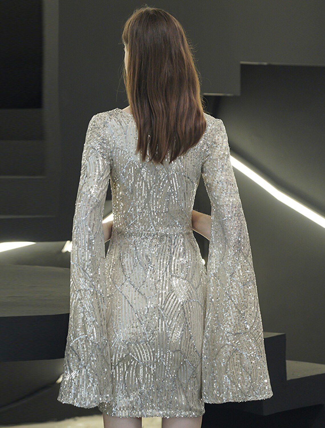 Elegant long sleeves of the sequin party dress, worn by a model.