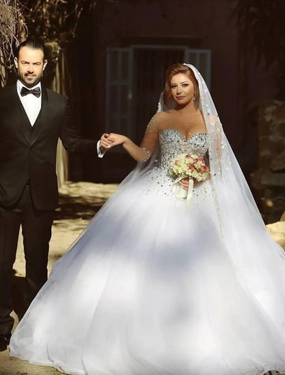 Model wearing a sparkling sweetheart strapless ball gown wedding dress with crystal beading.