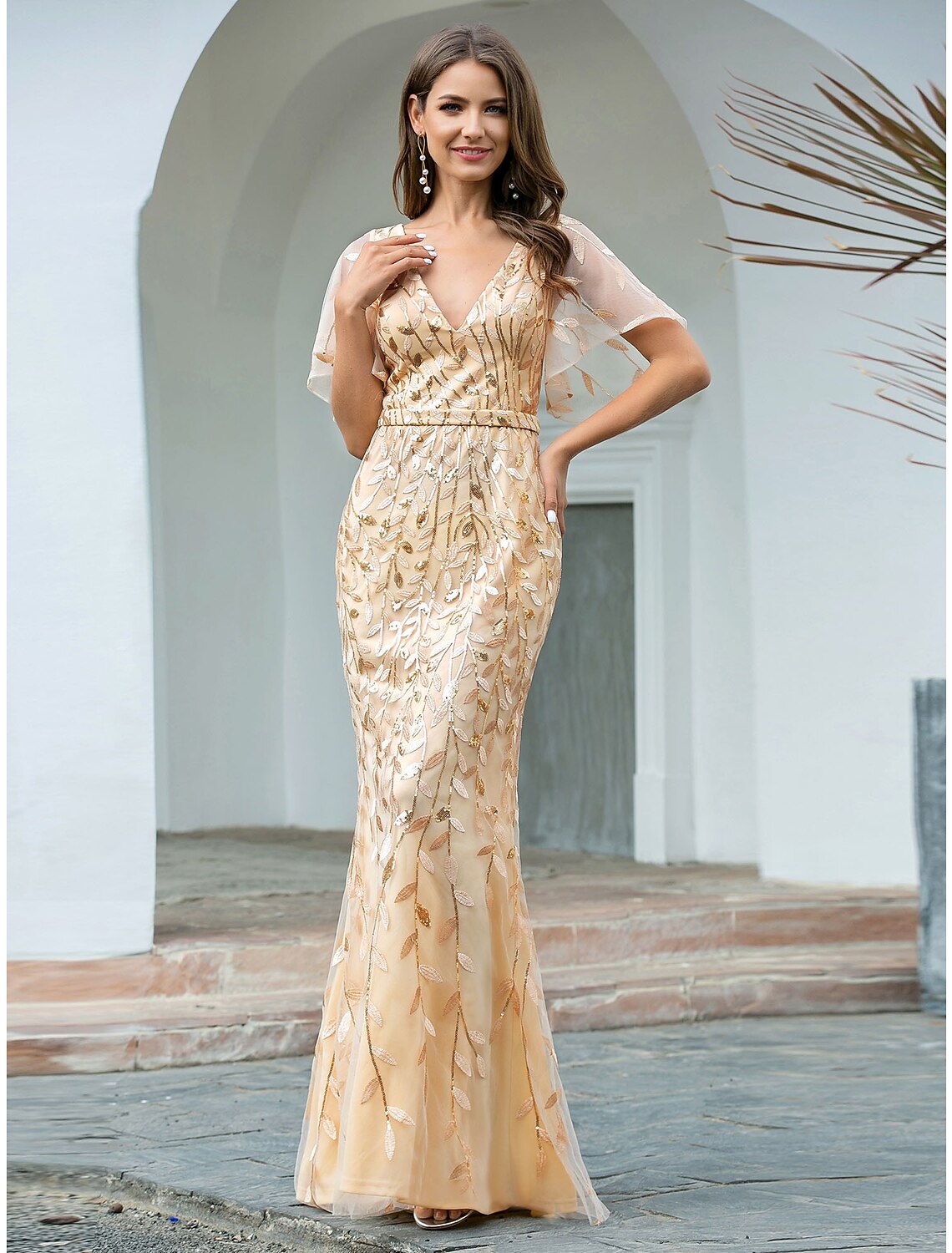 Woman wearing a sparkling V-neck short sleeve mermaid trumpet evening gown.