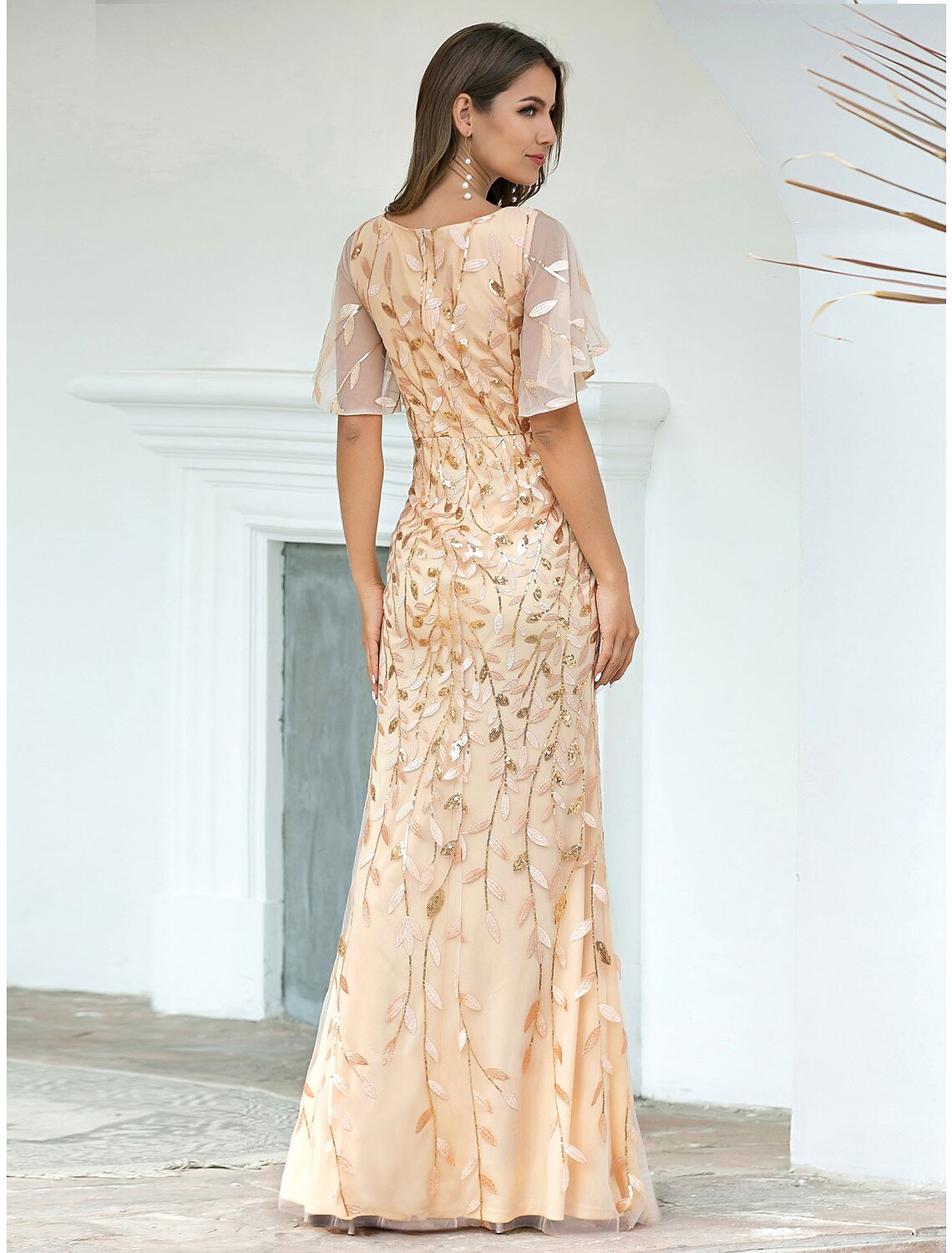 Close-up of the V-neckline and short sleeves of the sequin tulle evening gown.