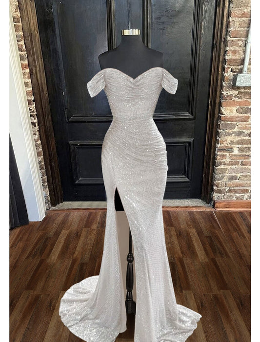 Model wearing a sparkly mermaid trumpet evening gown with a cowl neck and ruched details.