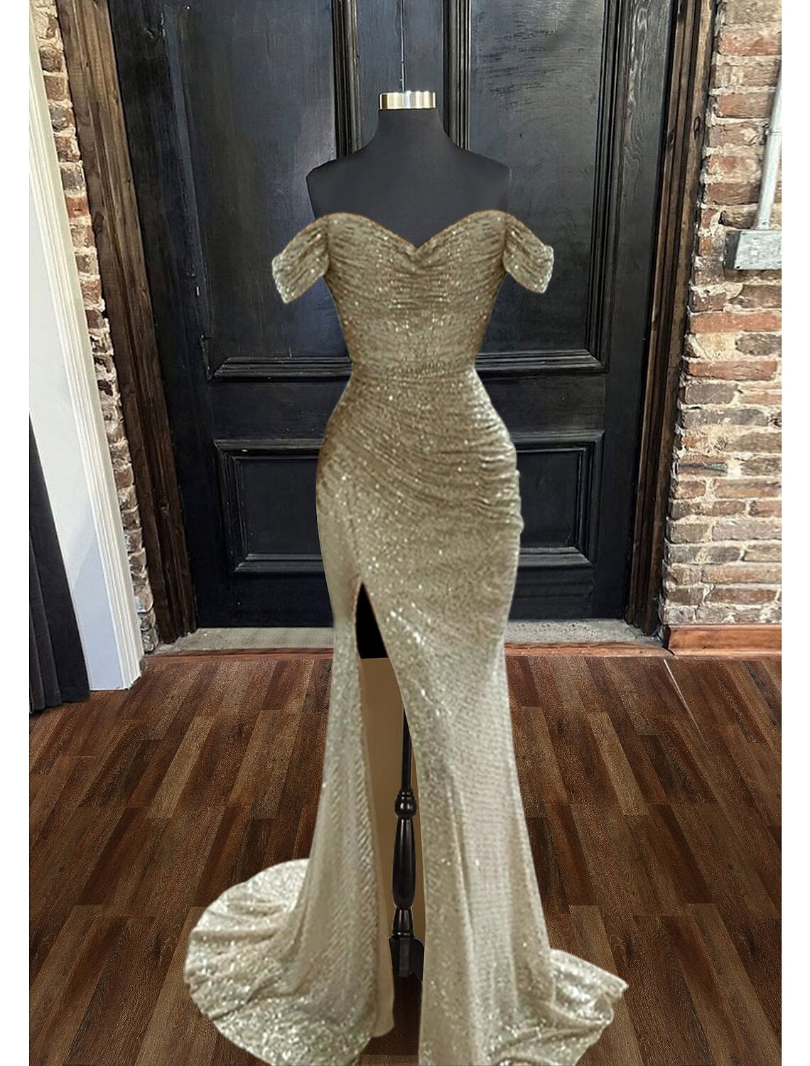 Model posing in a sleeveless sparkly evening dress with a trumpet silhouette.