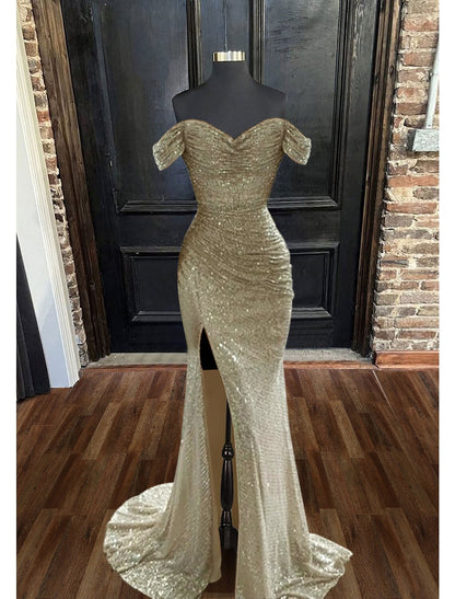Model posing in a sleeveless sparkly evening dress with a trumpet silhouette.