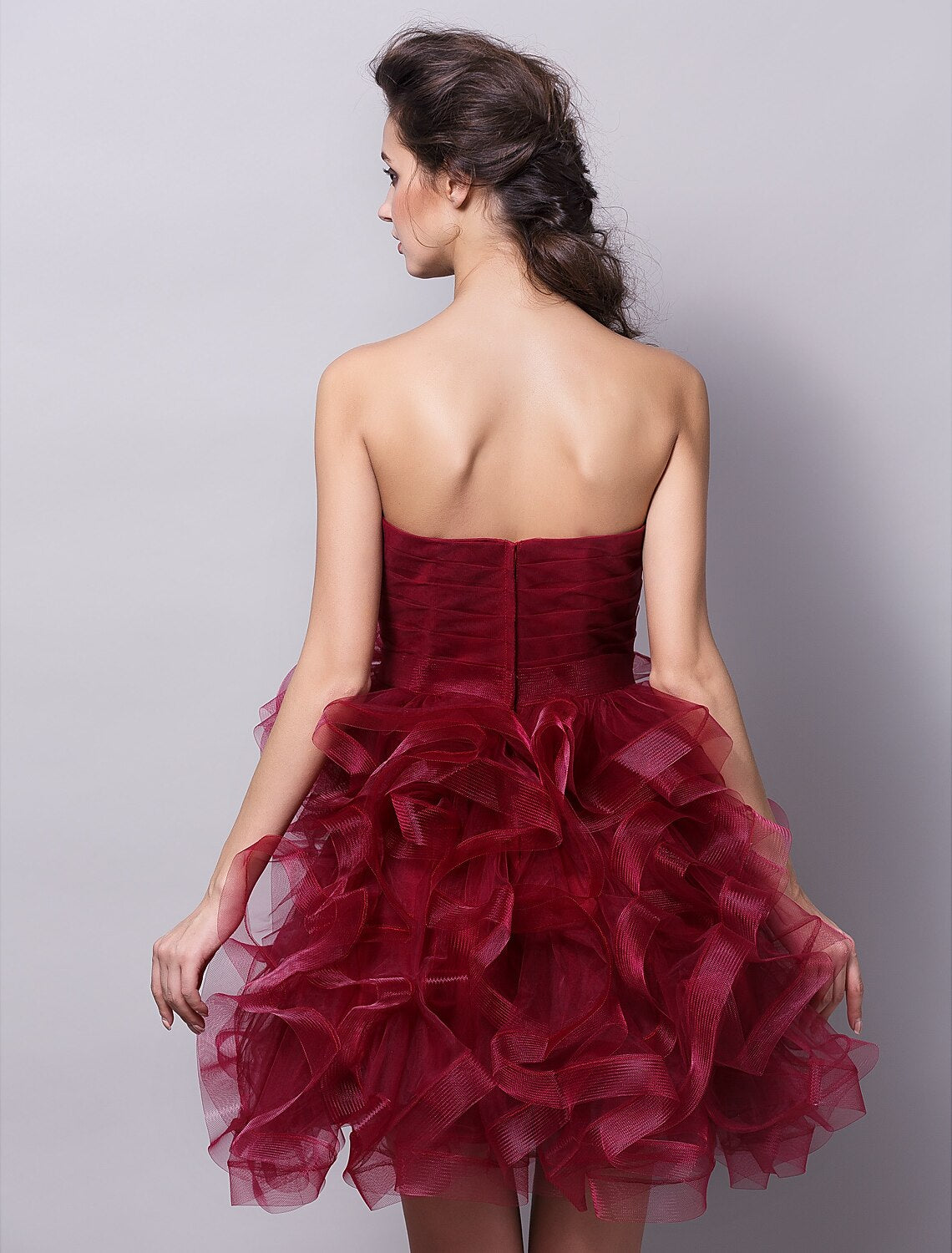 Close-up of the ruched tulle fabric and tiered design of the pink ball gown.