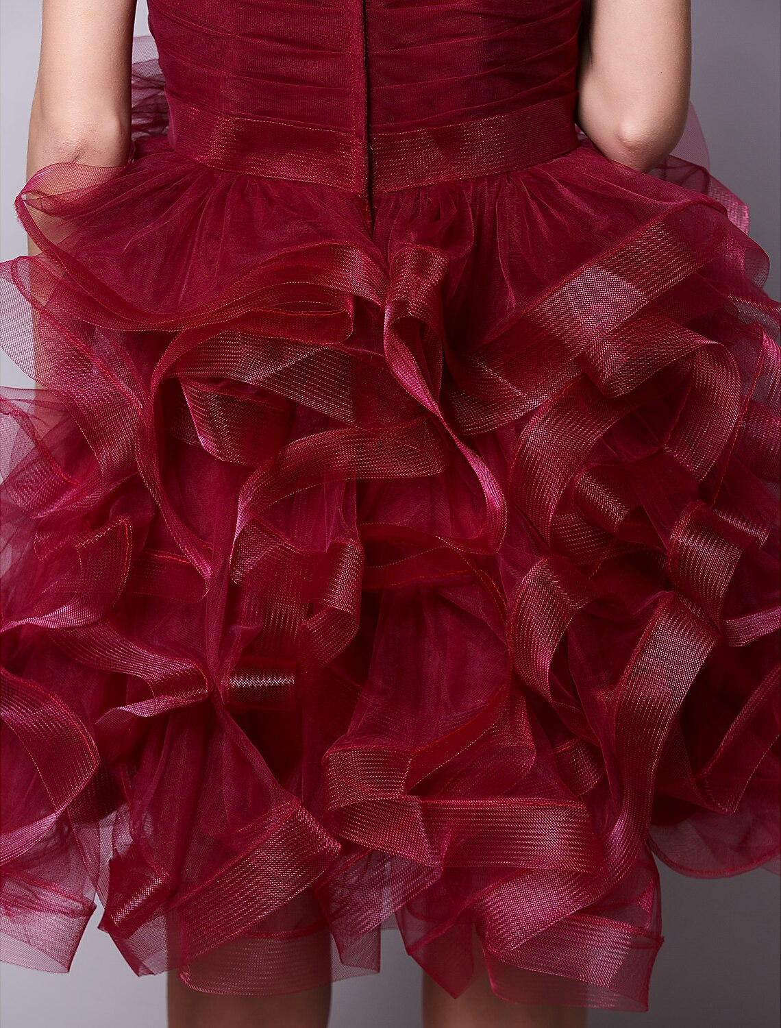 Model posing dynamically in the pink strapless cocktail dress, showing movement.