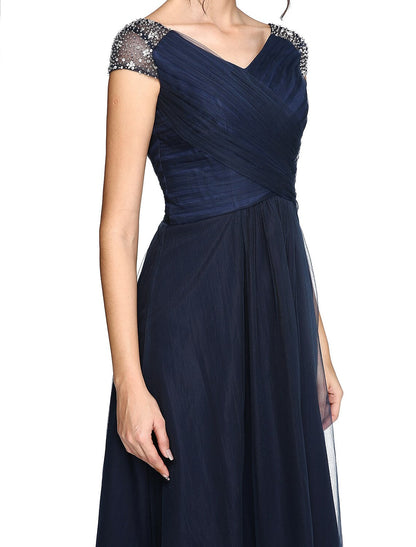 Vestido minimalista de corte tubo/columna para invitada de boda, asimétrico, manga corta, escote en V, tul, espalda en V con pliegues entrecruzados y abalorios.