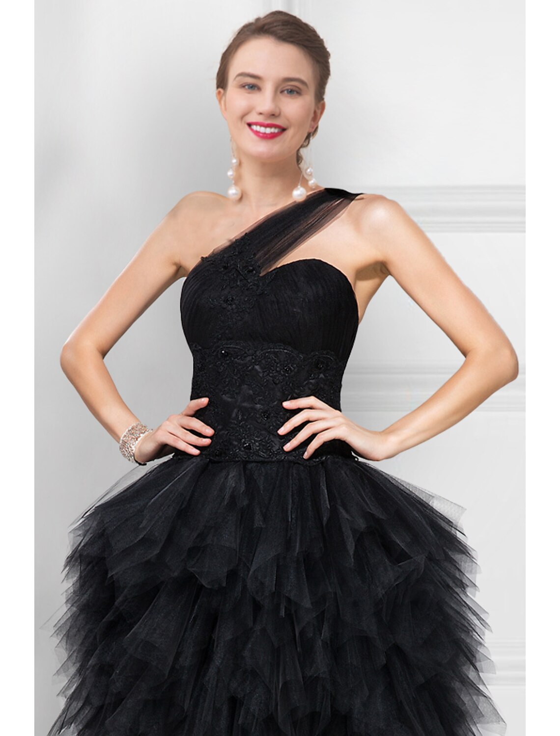 Vestido de fiesta negro de tul con escote en V, asimétrico, sin mangas, con un solo hombro y espalda descubierta en color puro.